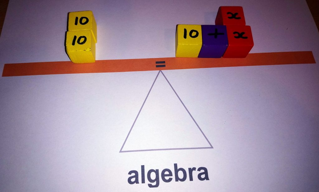 picture of a seesaw with algebraic formula represented with wooden blocks.